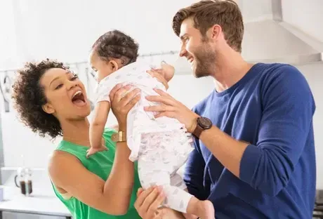A man and a woman are holding a baby in their arms.