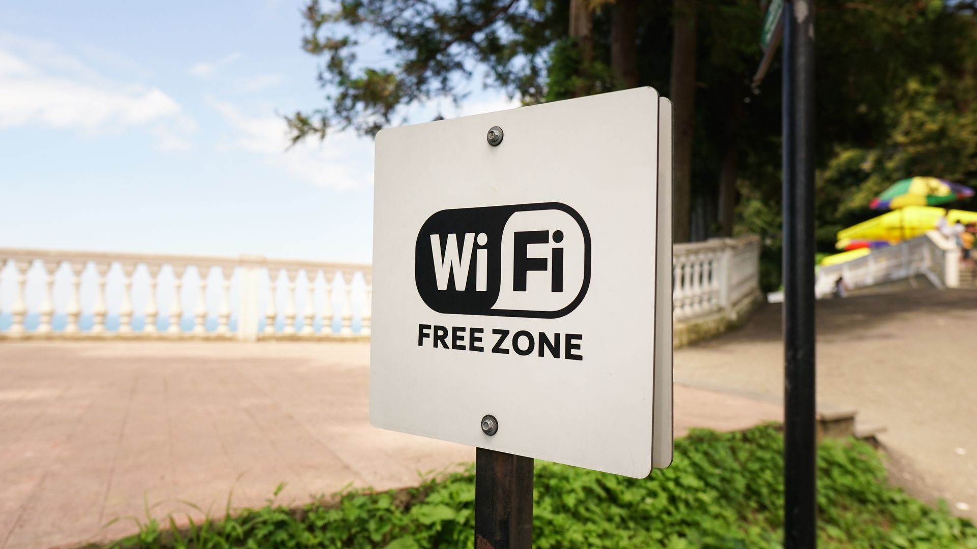 A white sign on a pole that says `` wifi free zone ''.