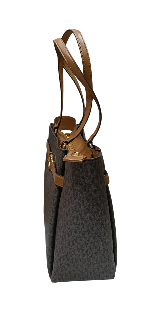 Bolso tote marrón con asas marrones y detalle de cinturón con emblema dorado.