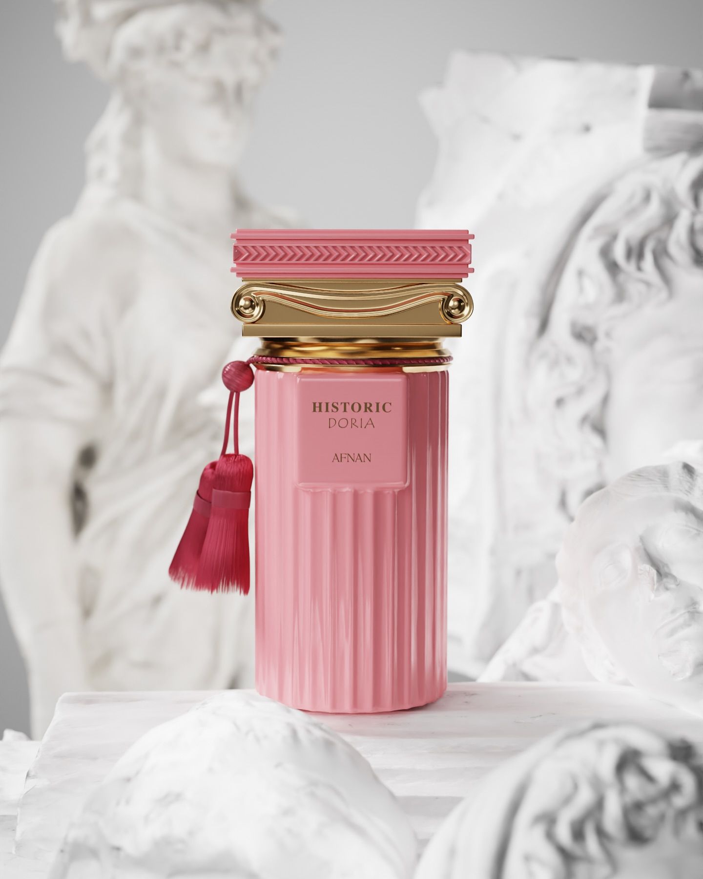 Frasco de perfume rosa con detalles dorados y borla, decorado con estatuas clásicas.