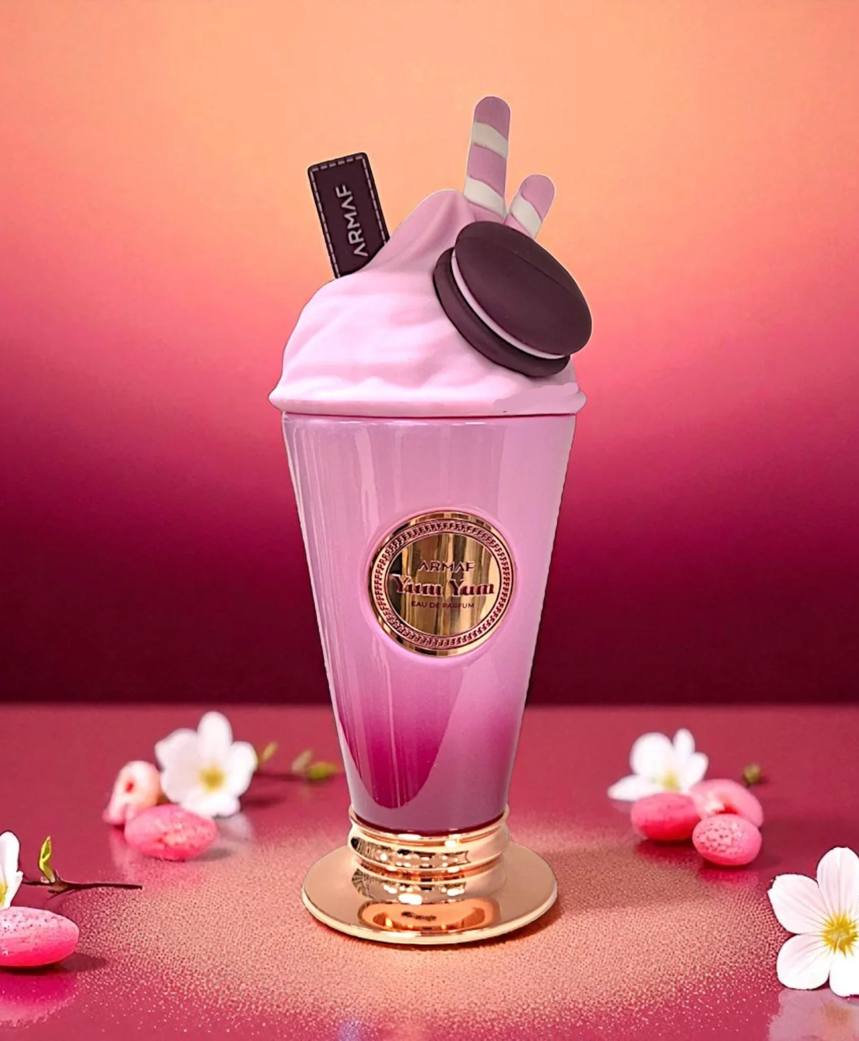 Botella de perfume de batido rosa con chocolate y galletas como decoración.