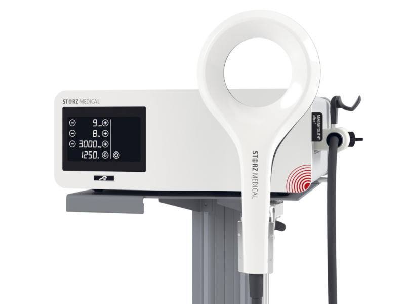 White medical device with a circular applicator, on a stand.