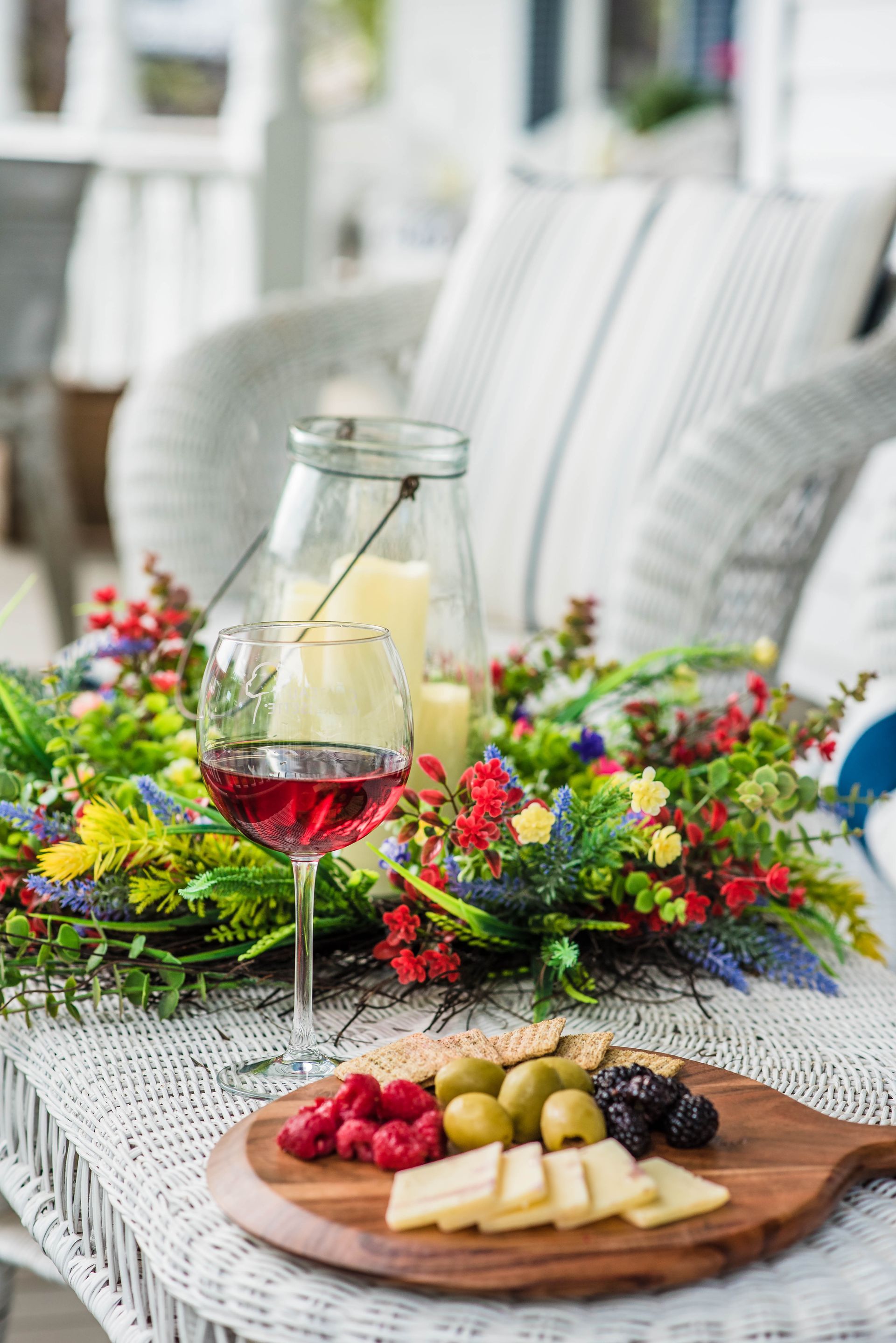 There is a glass of wine and a plate of food on the table.