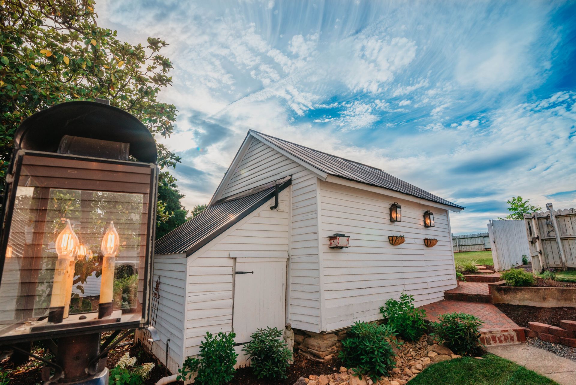 A white house with a treehouse in front of it.
