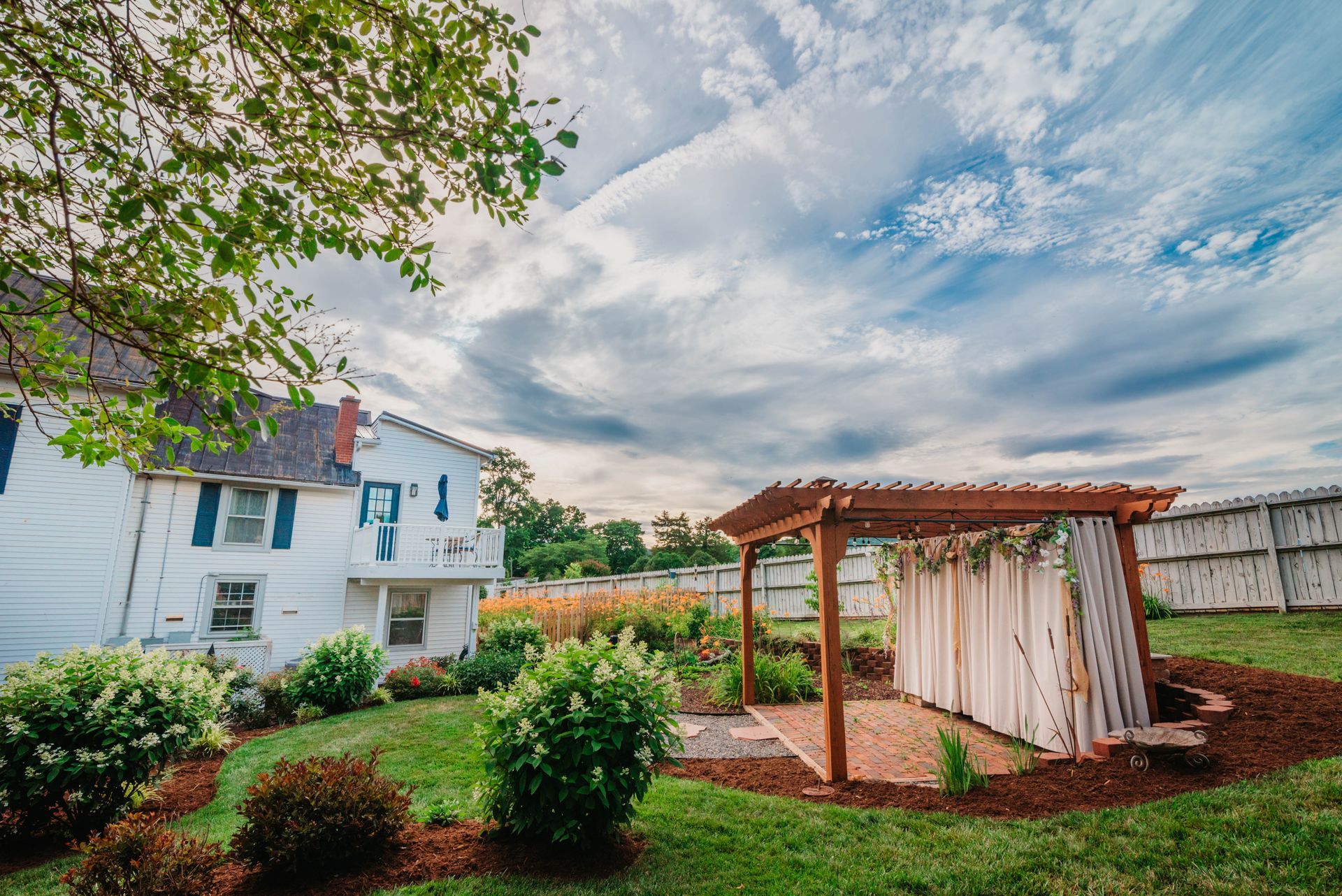 There is a pergola in the backyard of a house.