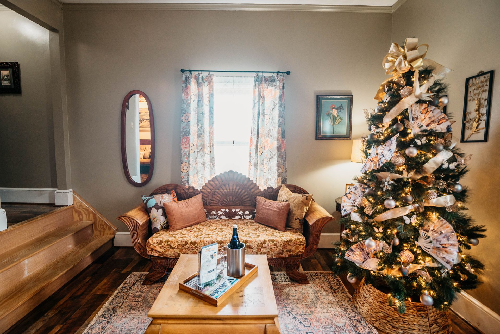 A living room with a couch , coffee table , and christmas tree.