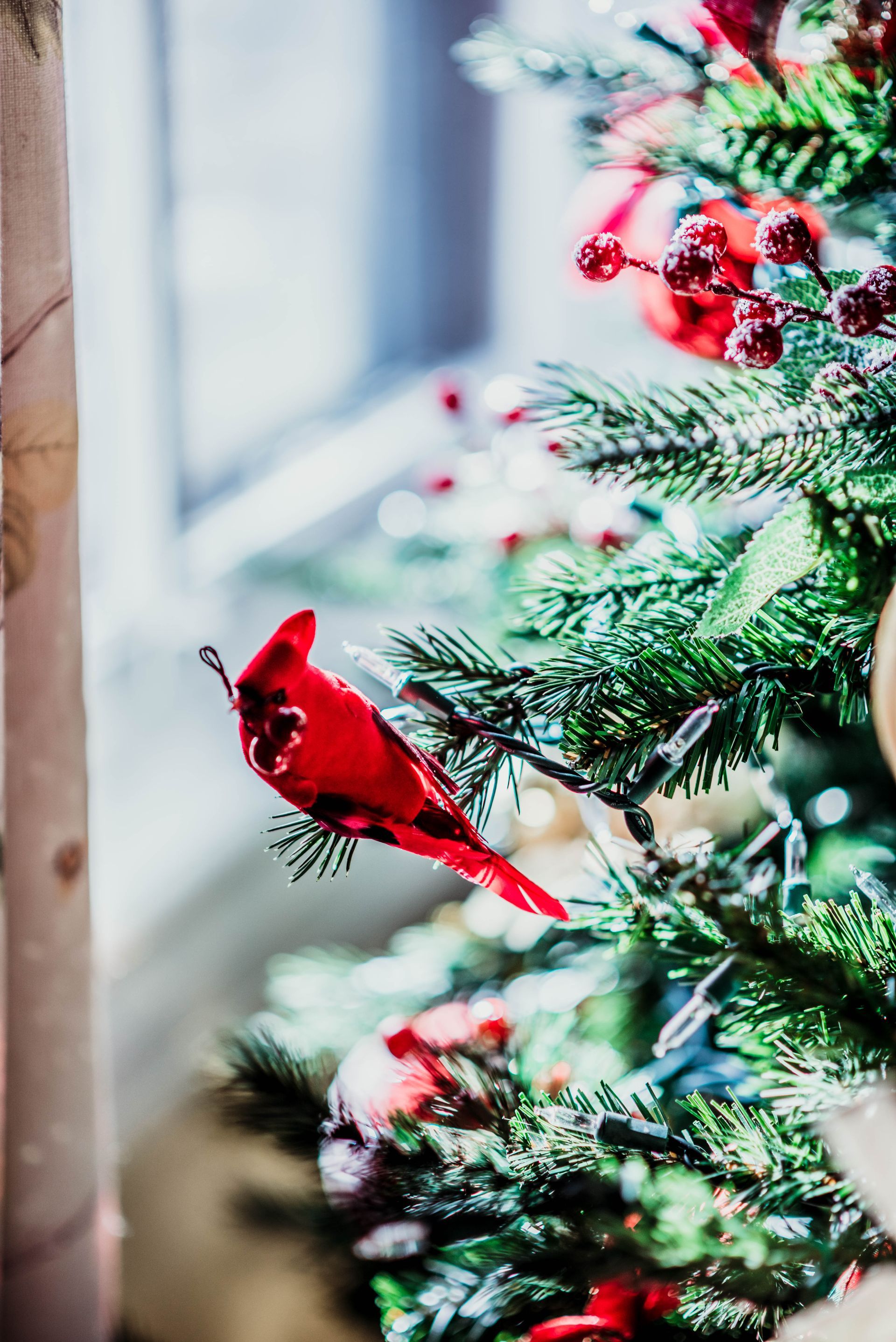 A close up of a christmas tree with a red bird on it.