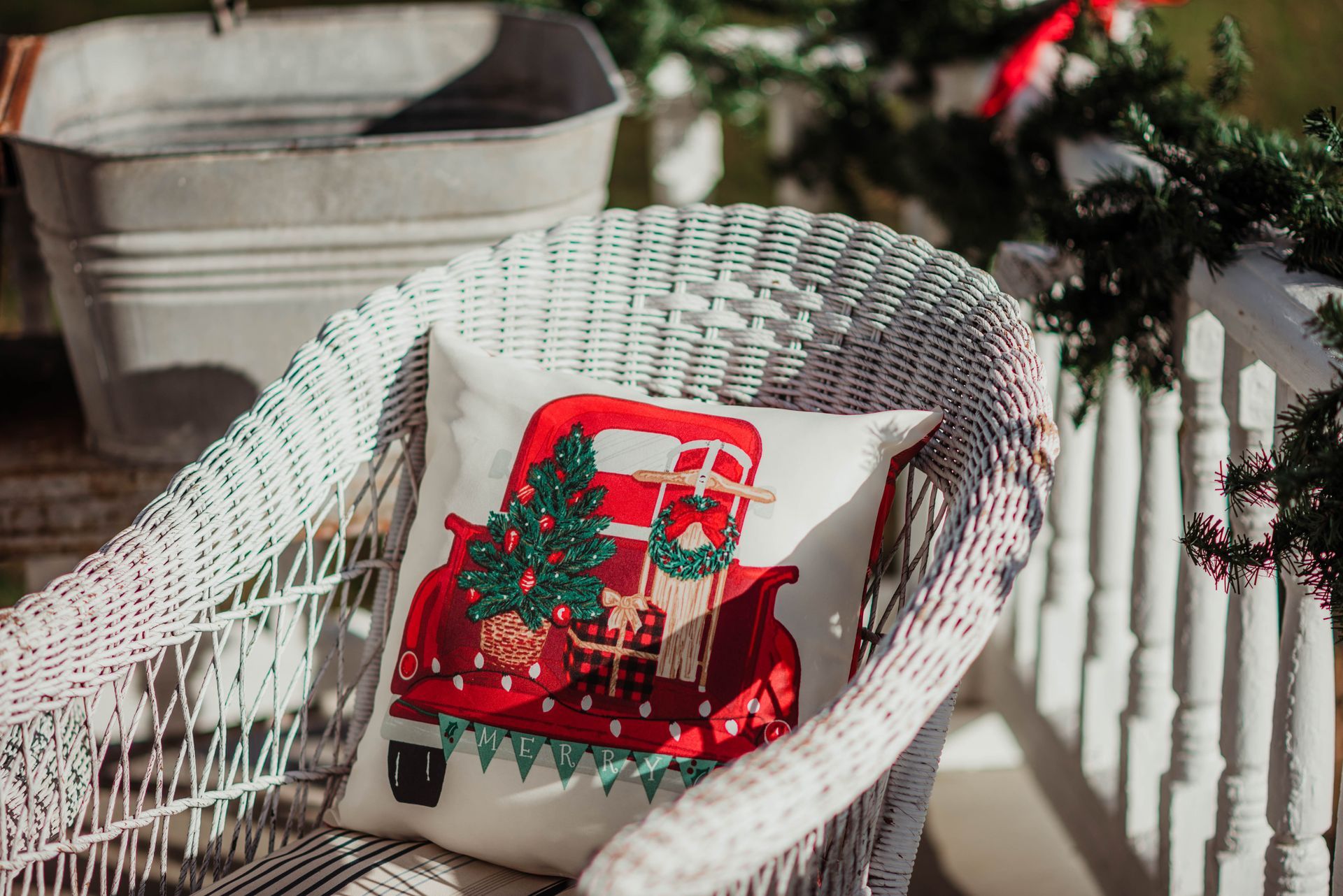A wicker chair with a christmas pillow on it.