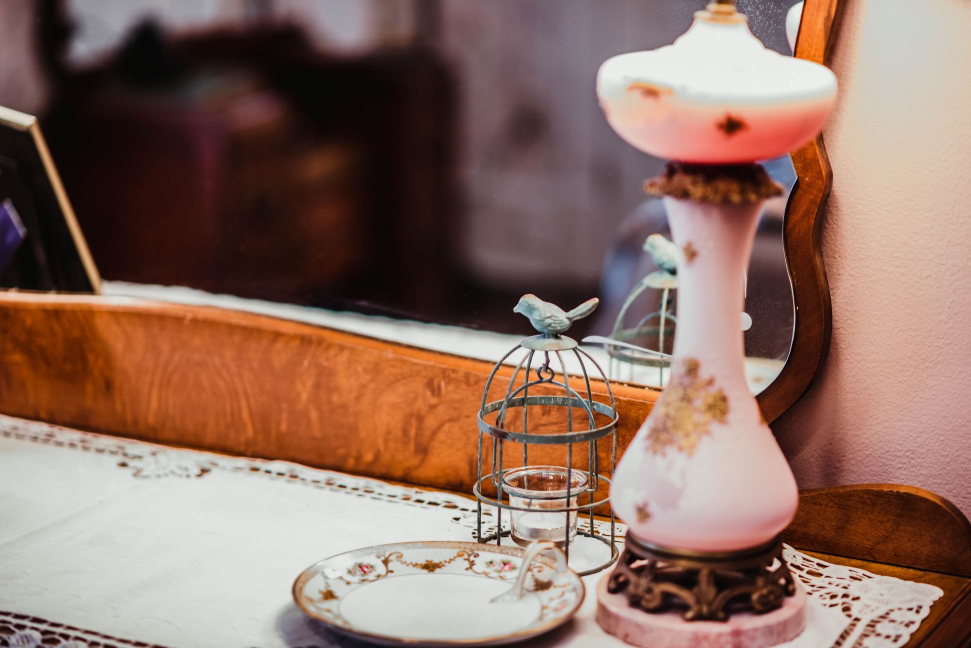 A lamp is sitting on a table next to a mirror.