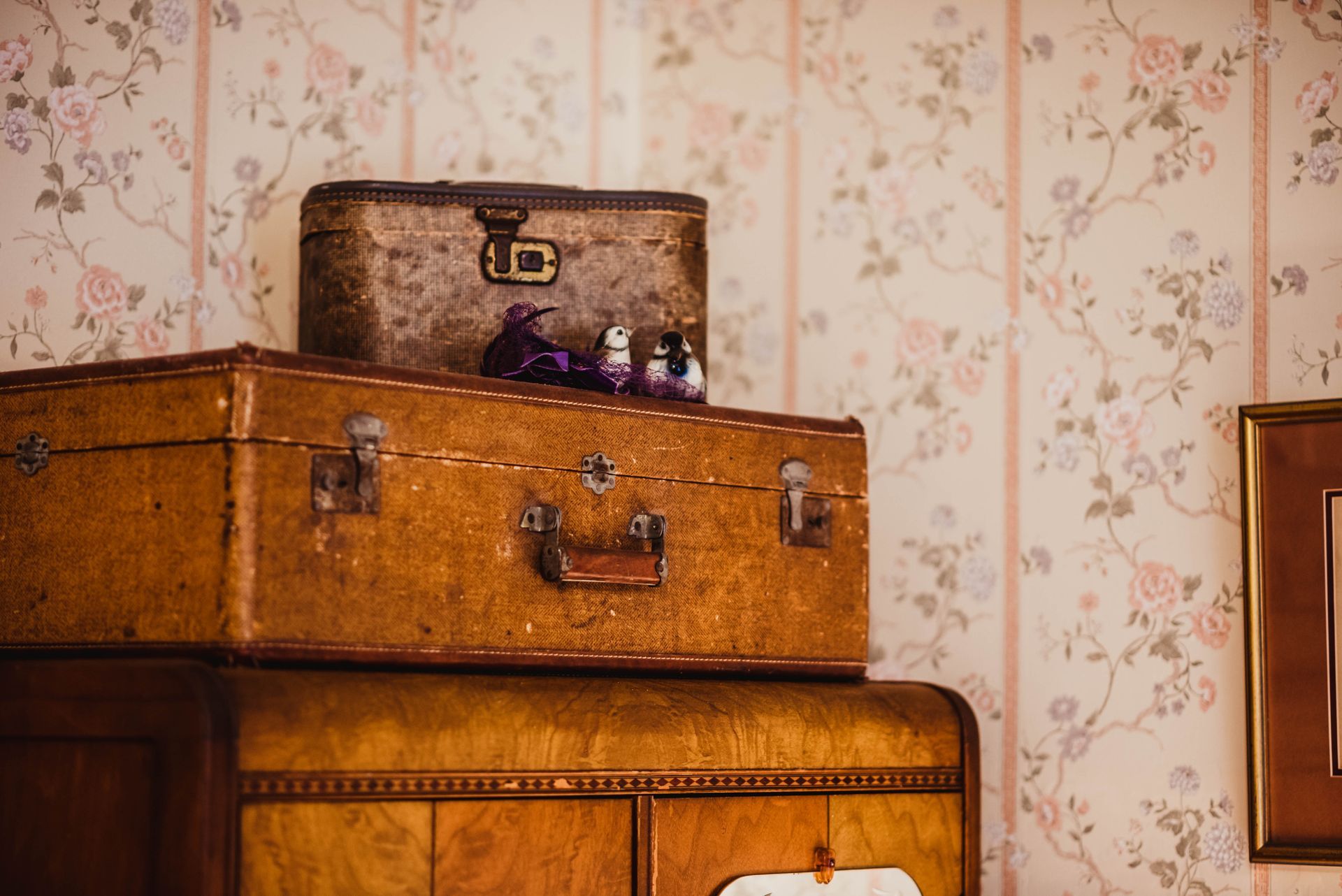 Three suitcases are stacked on top of each other in a room.