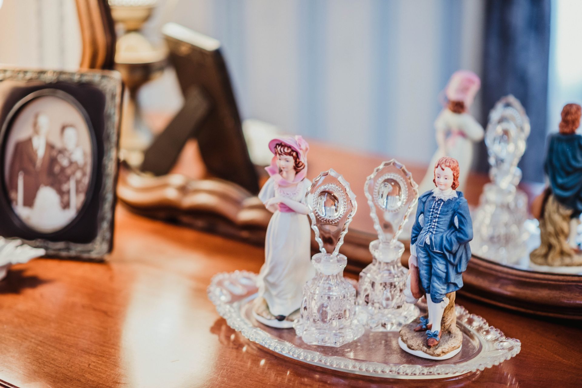 A couple of figurines sitting on top of a glass tray on a table.