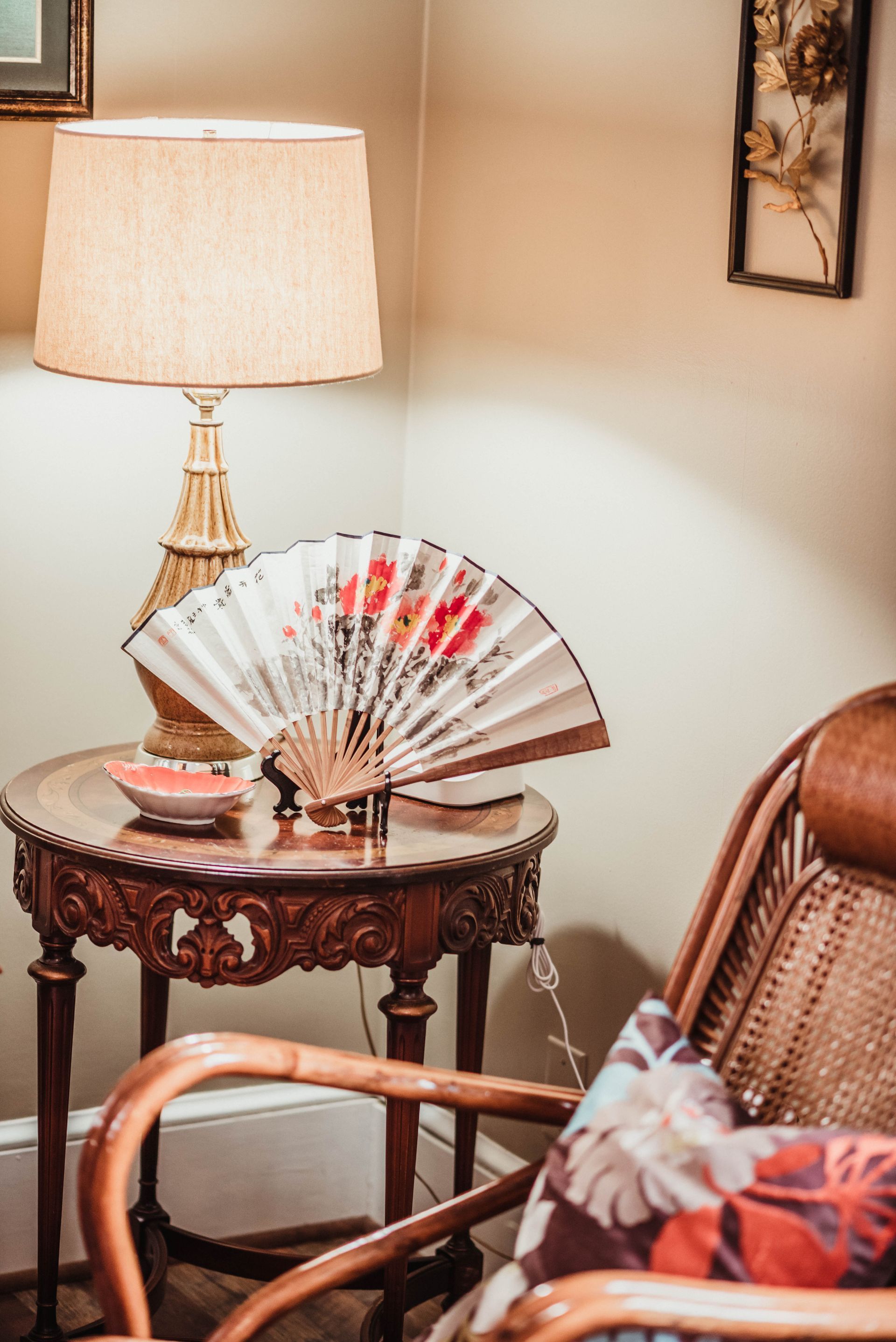 A fan is sitting on a table next to a lamp.