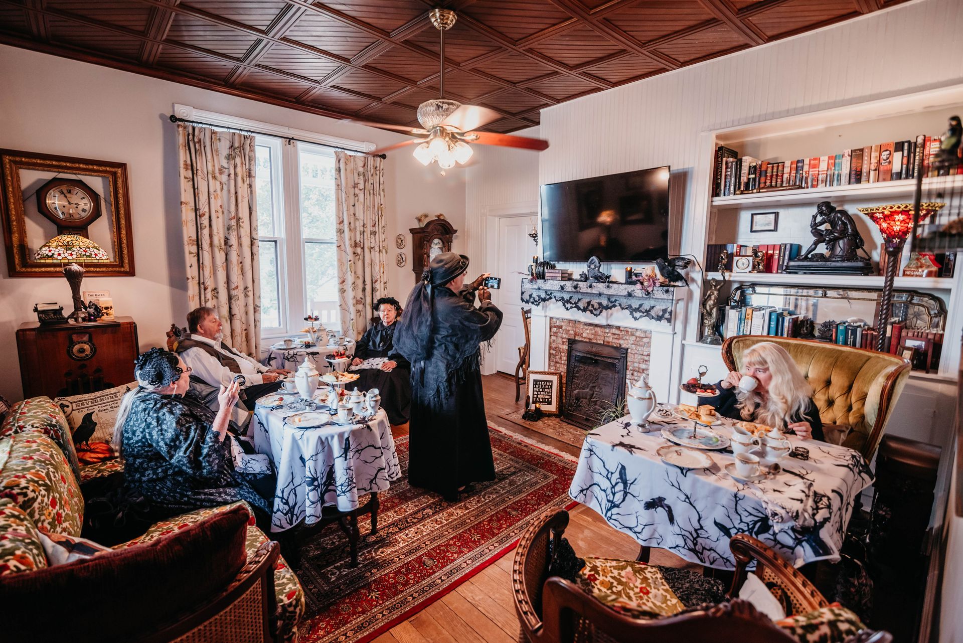 A group of people are sitting around a table in a living room.