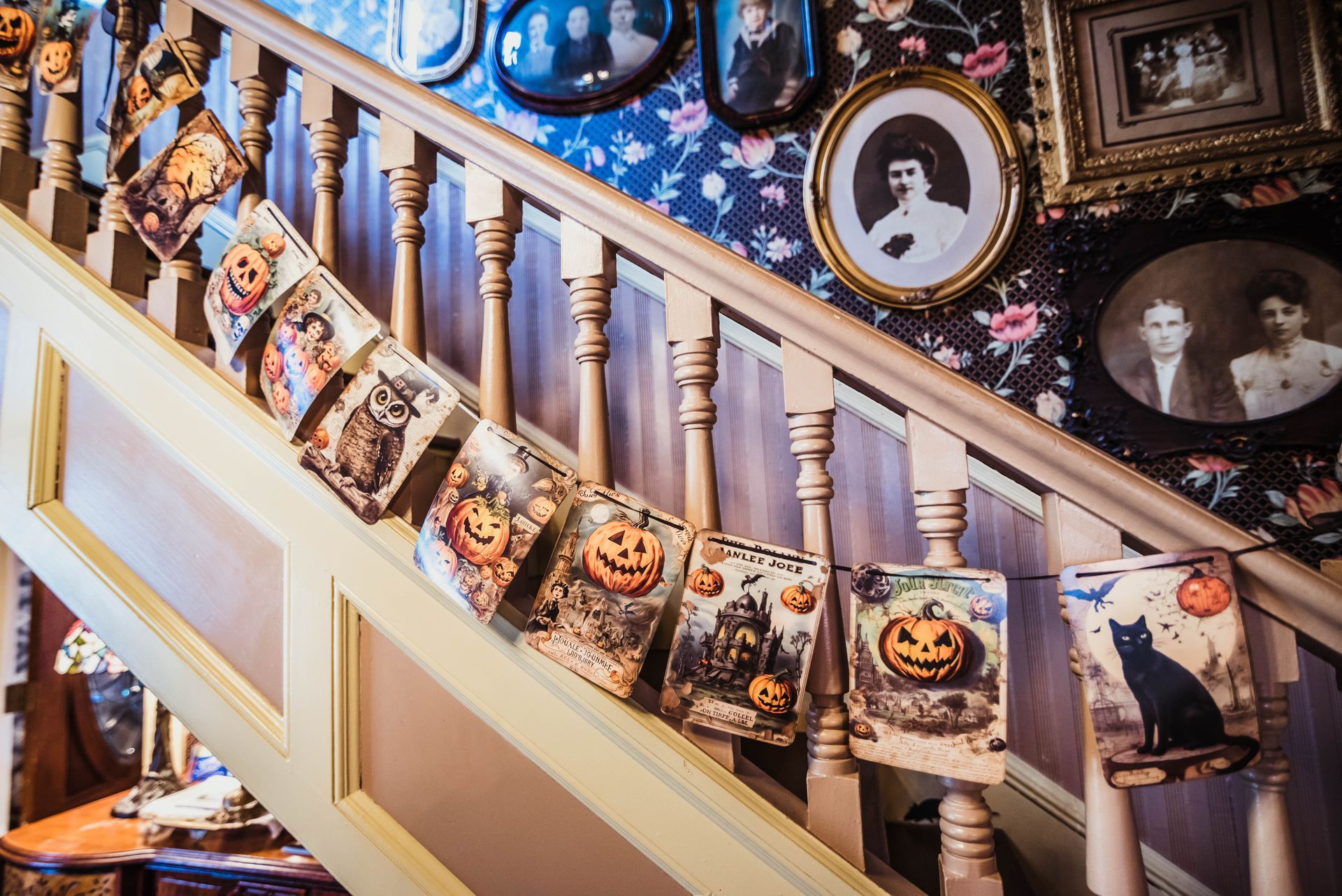 A staircase decorated for halloween with pumpkins and a black cat.