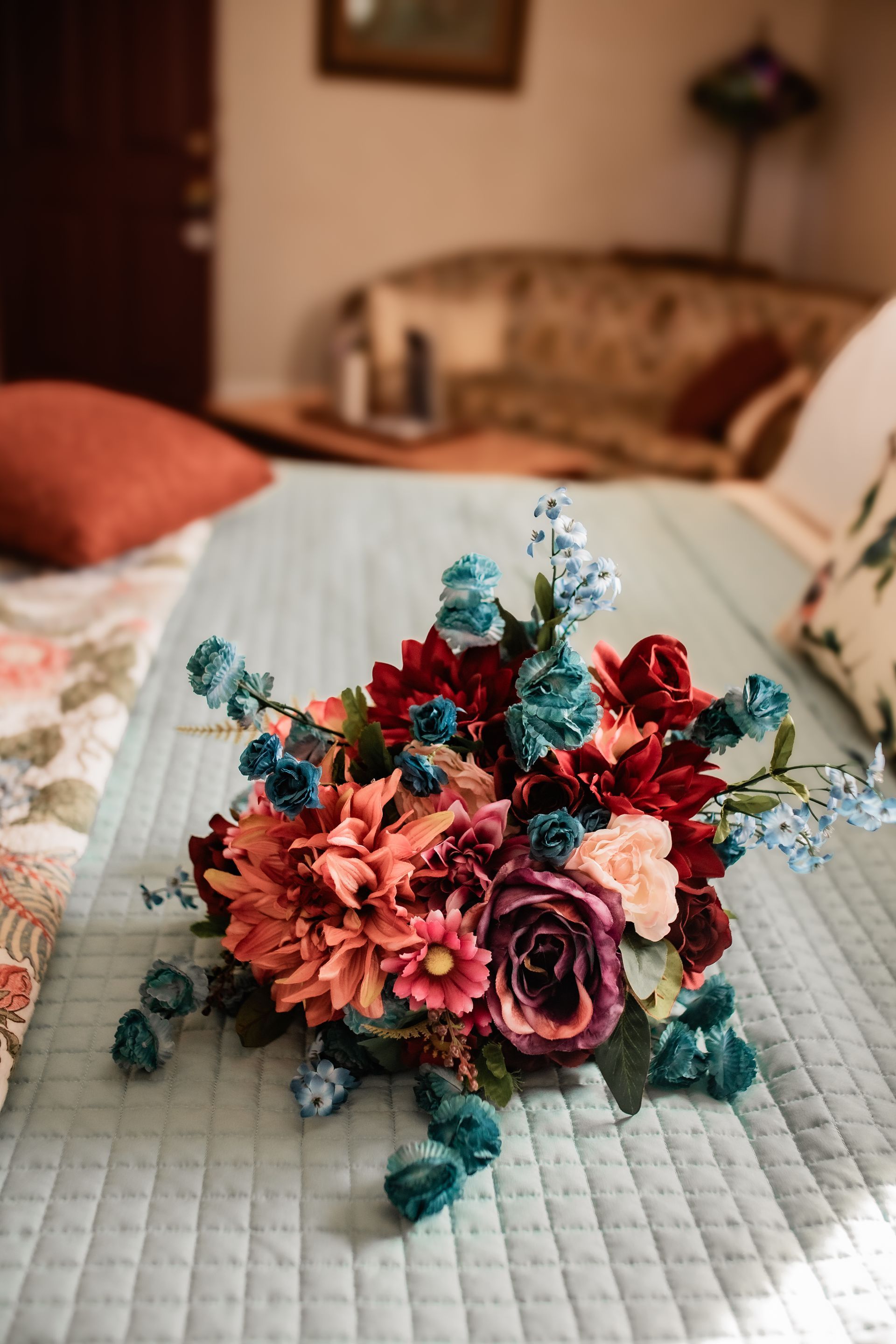 A bouquet of flowers is sitting on top of a bed.