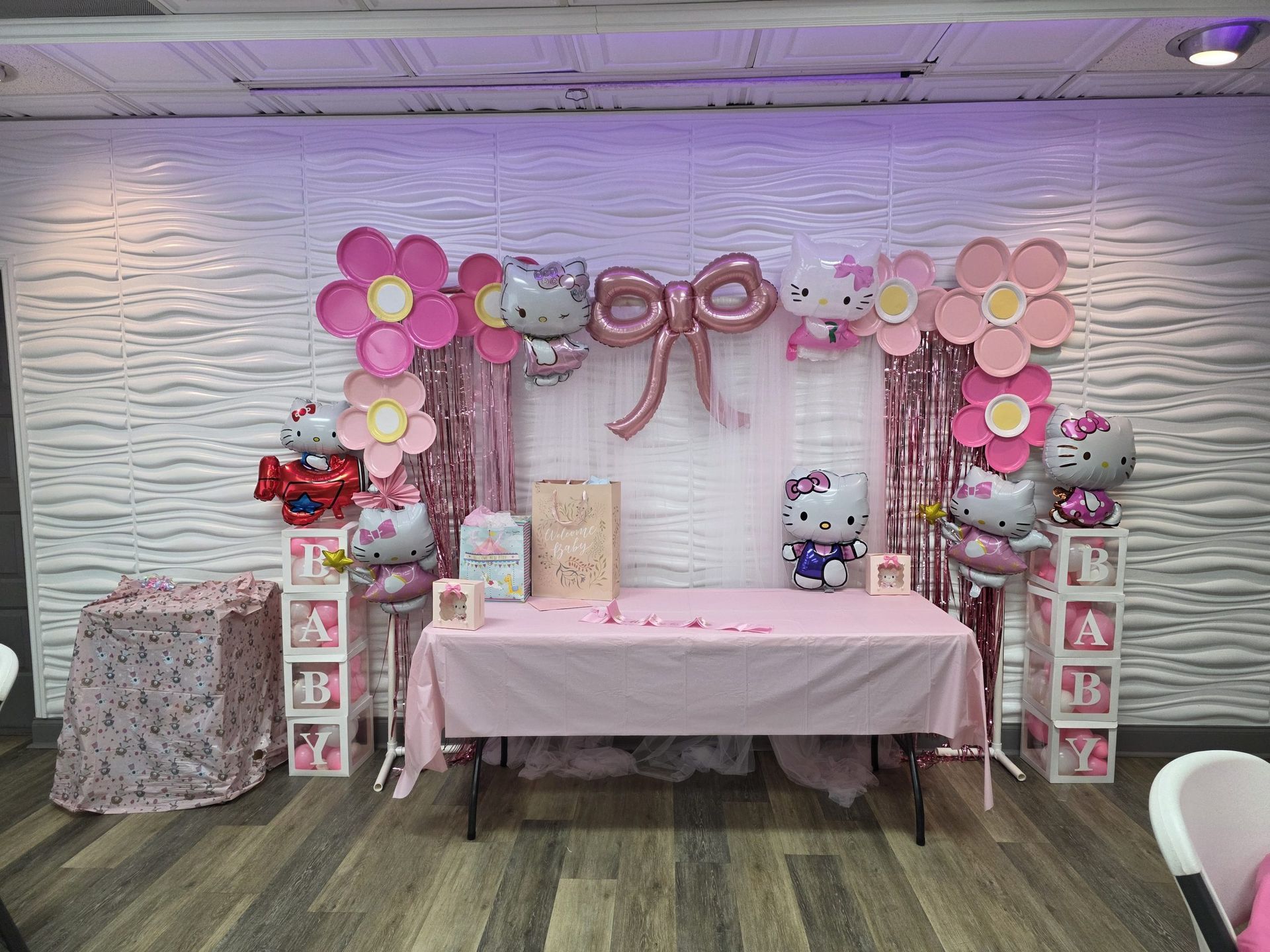 Woman in straw hat smiles, holding wine glass near a lake.