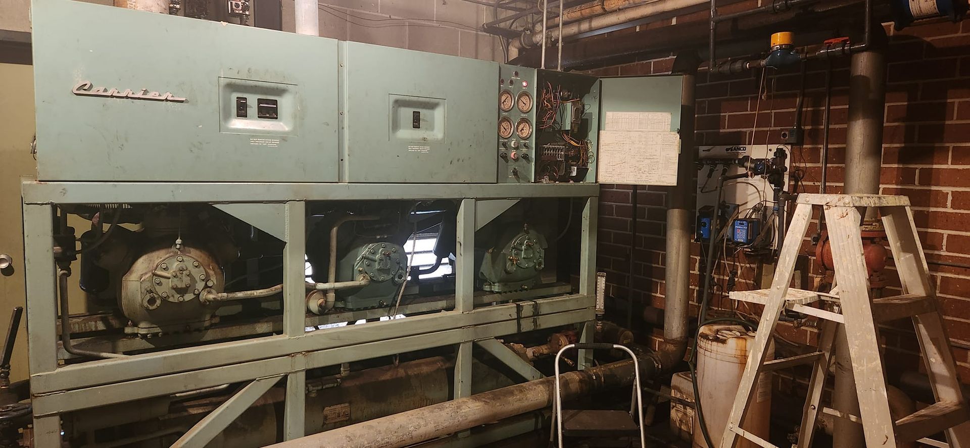 A machine is sitting in a room next to a ladder.