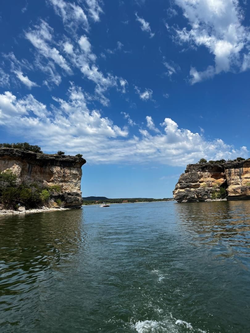 A large body of water with a cliff in the background