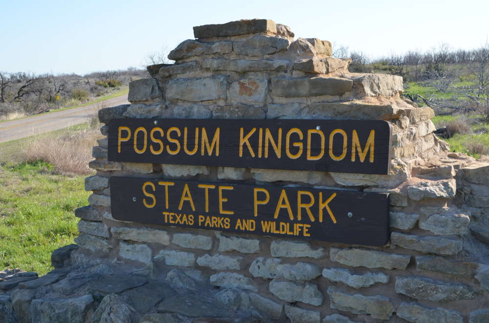 A stone wall with a sign that says possum kingdom state park