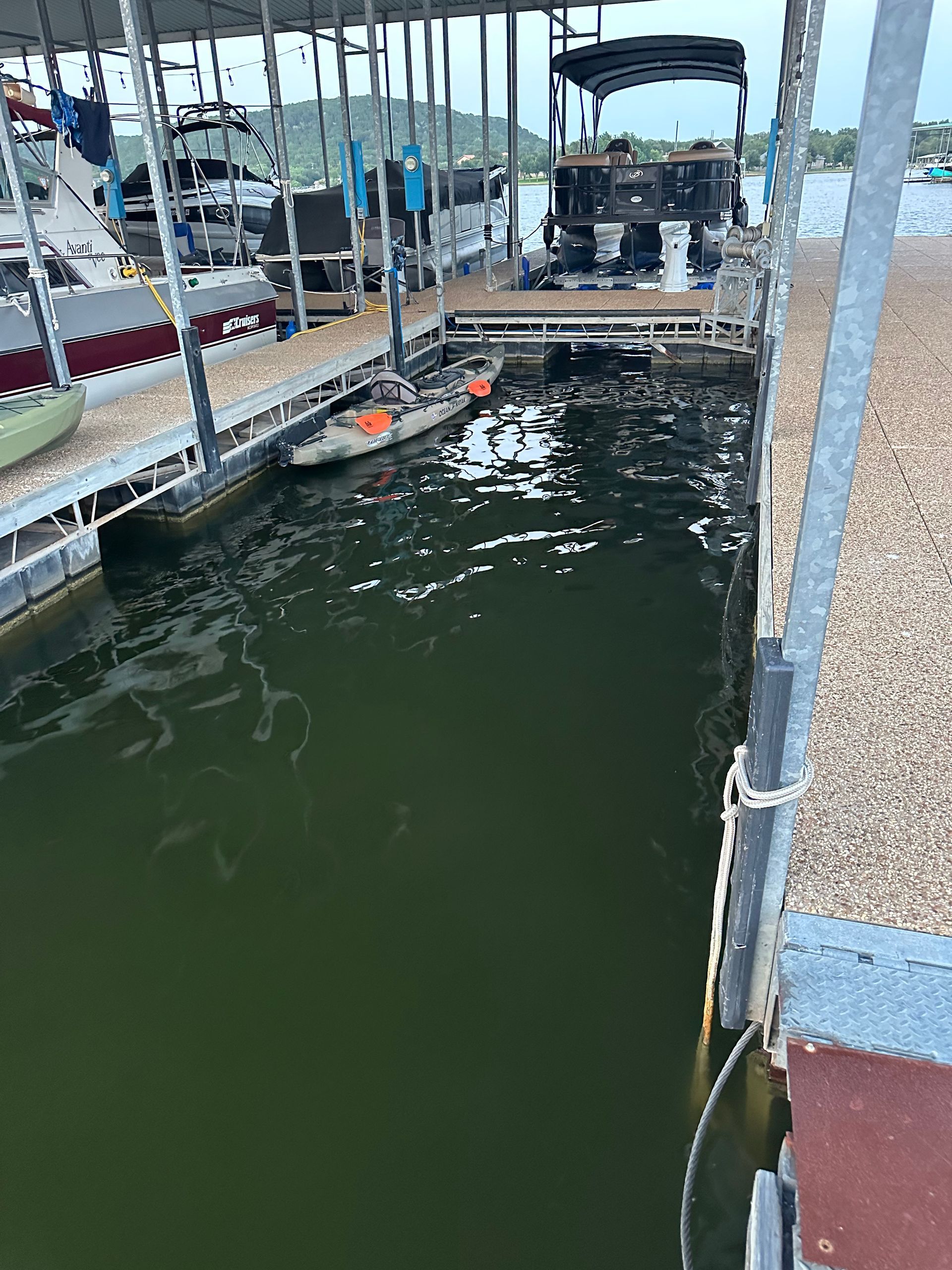 A boat is docked at a dock next to a body of water.
