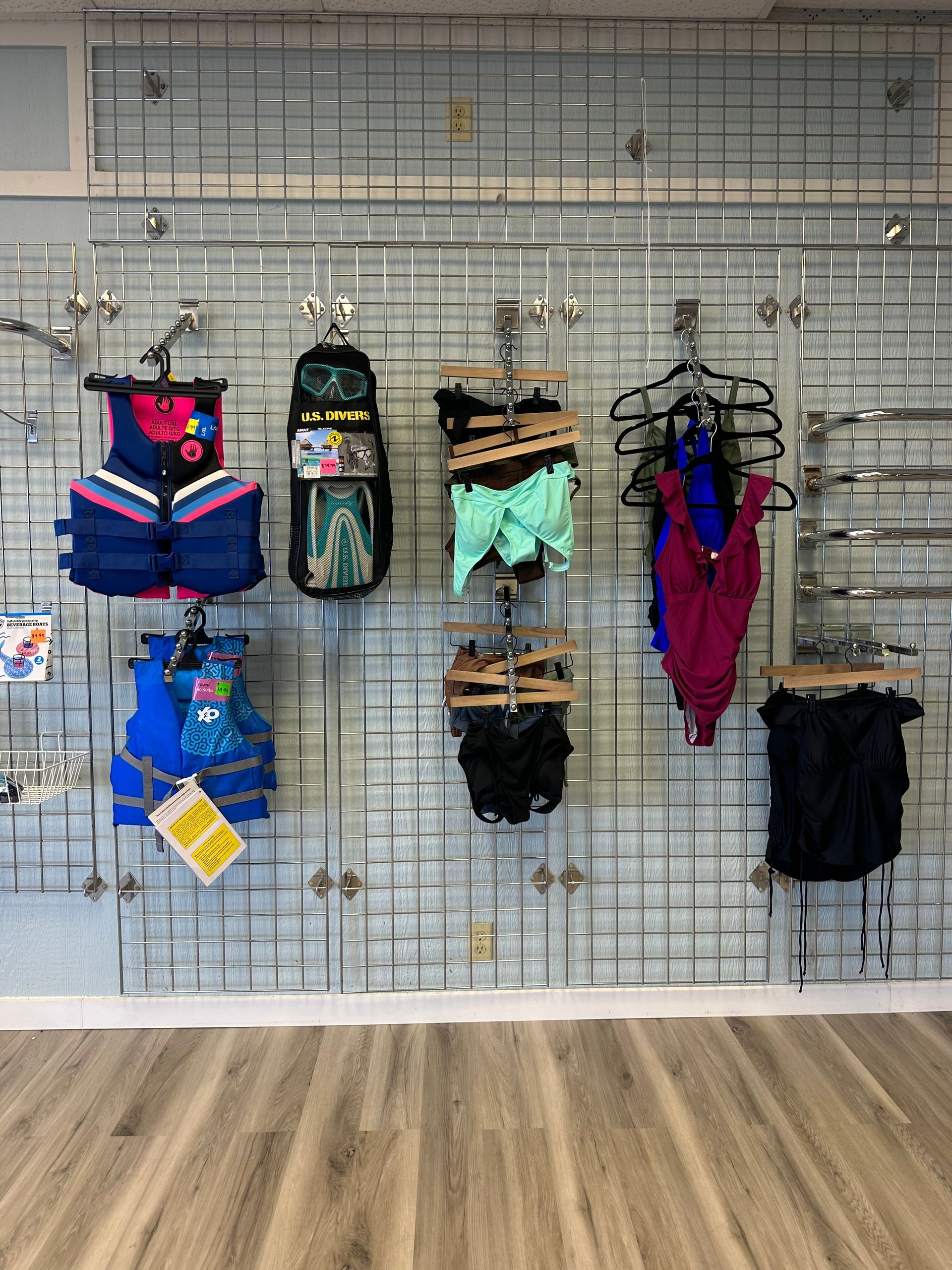 A display of swimsuits hanging on a wall in a store.