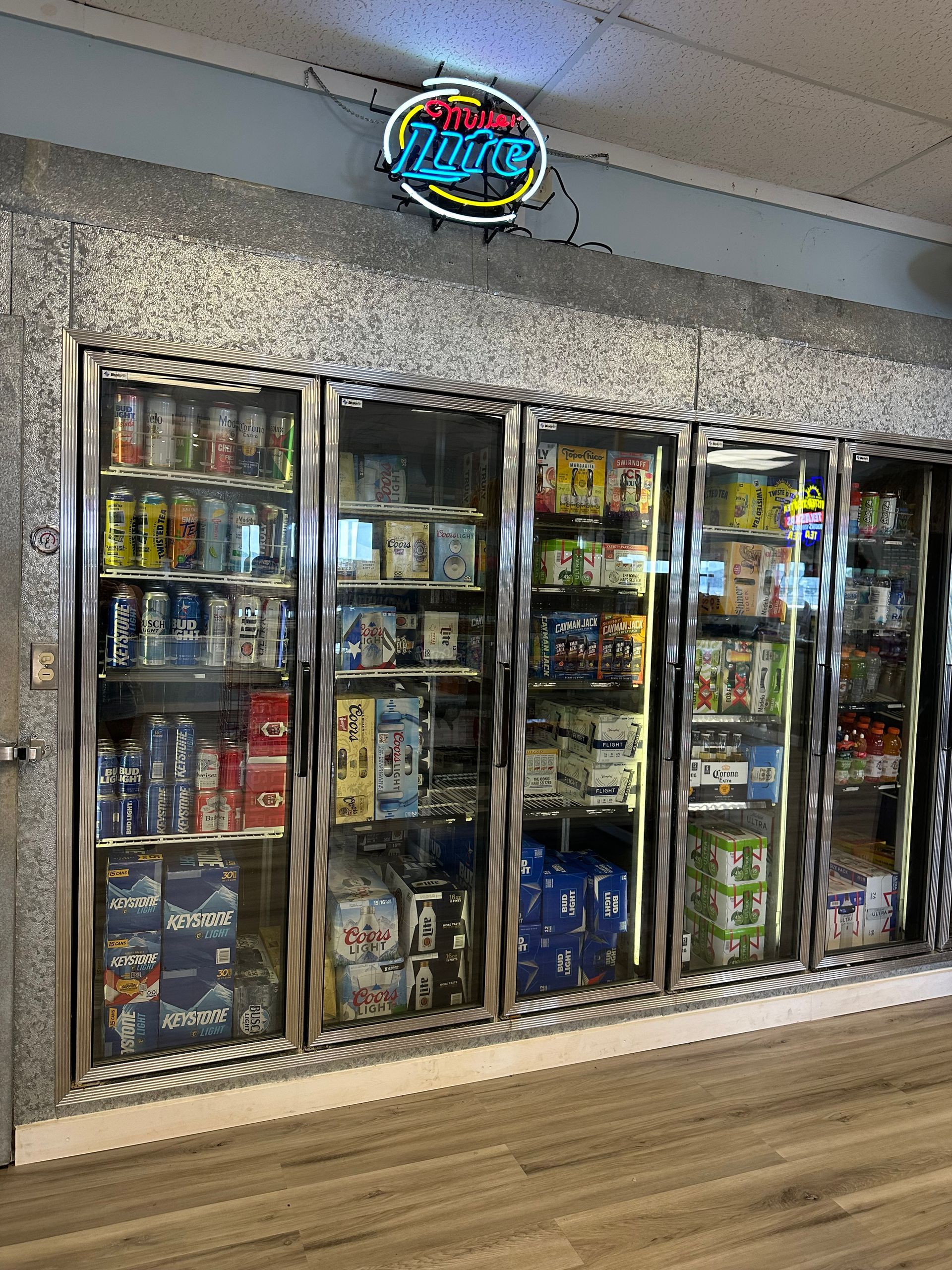 A grocery store with a lot of beer in the freezers.