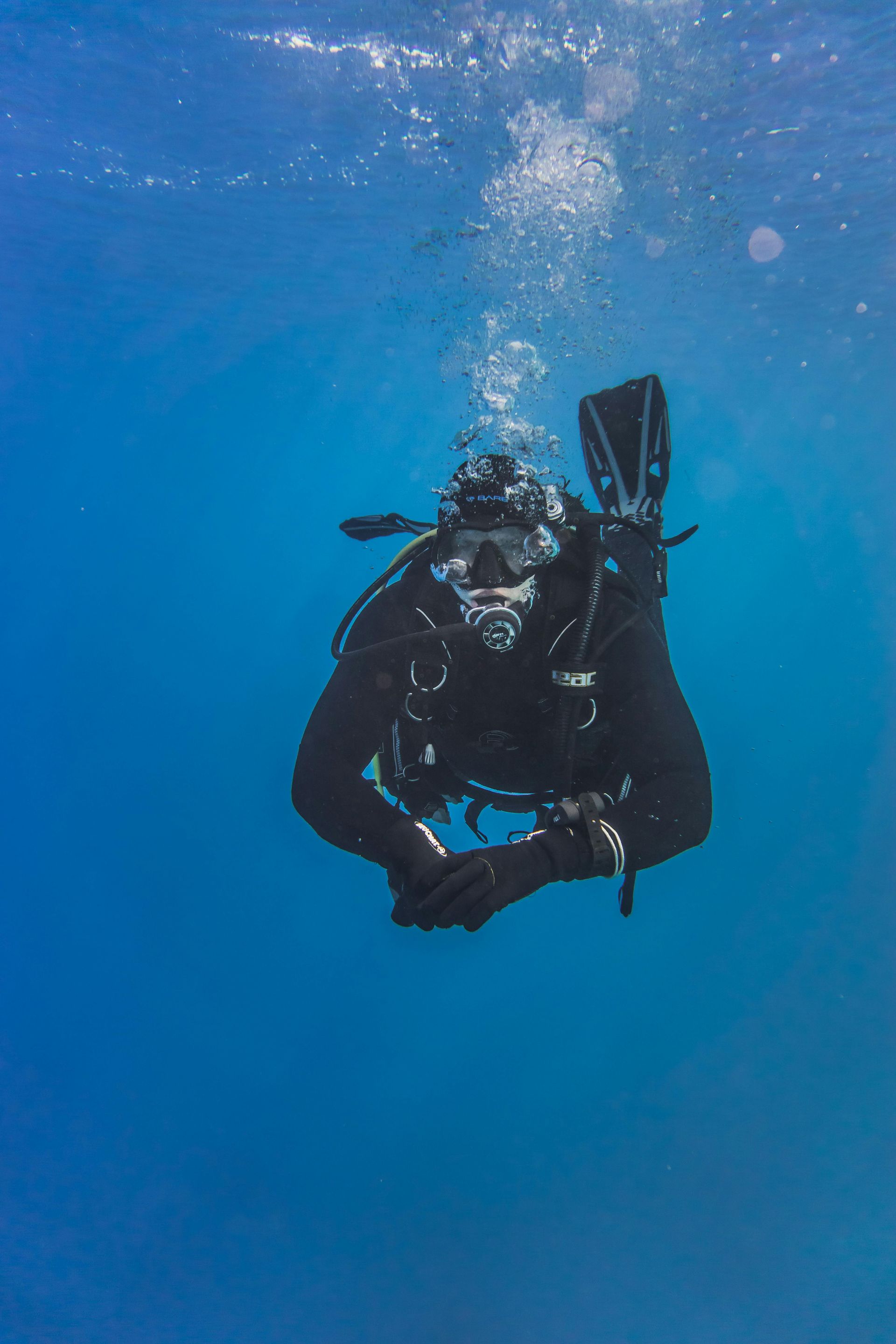 A scuba diver is swimming underwater in the ocean.