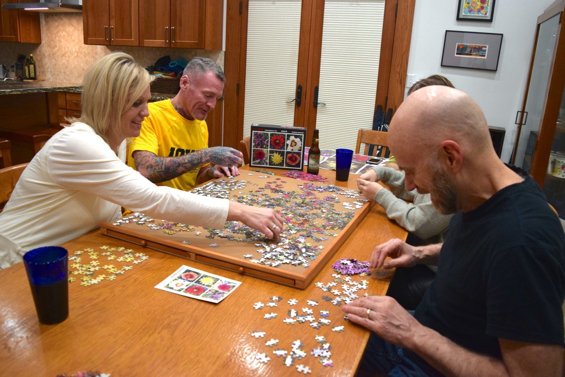 four people assembling a jigsaw puzzle on a flat surface