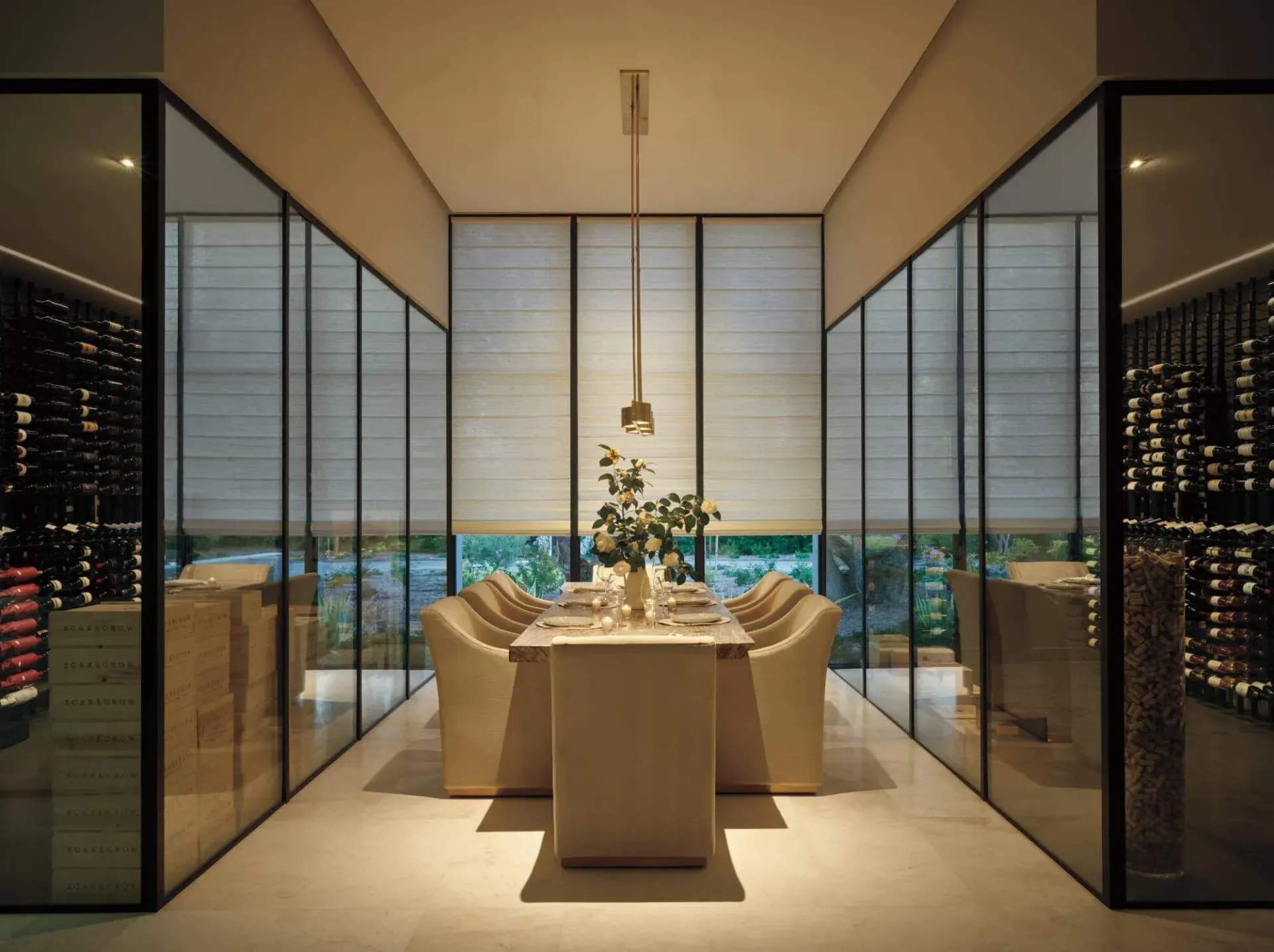 Elegant dining room with a long table set for dinner, overlooking a city skyline through floor-to-ceiling windows