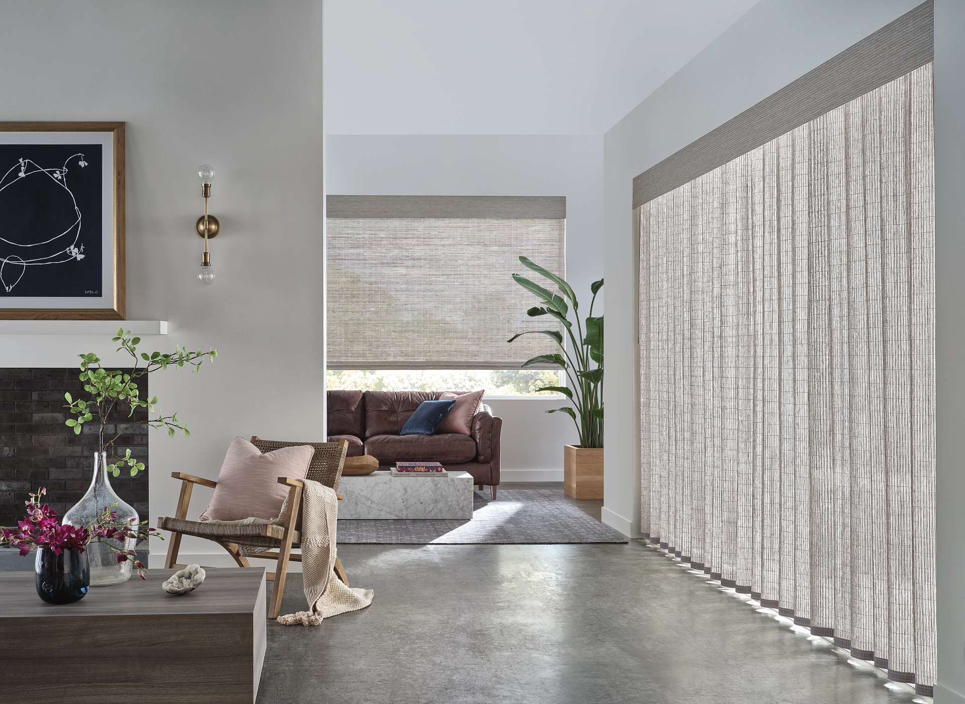 Modern living room with stone fireplace, neutral decor, and sheer curtains filtering light