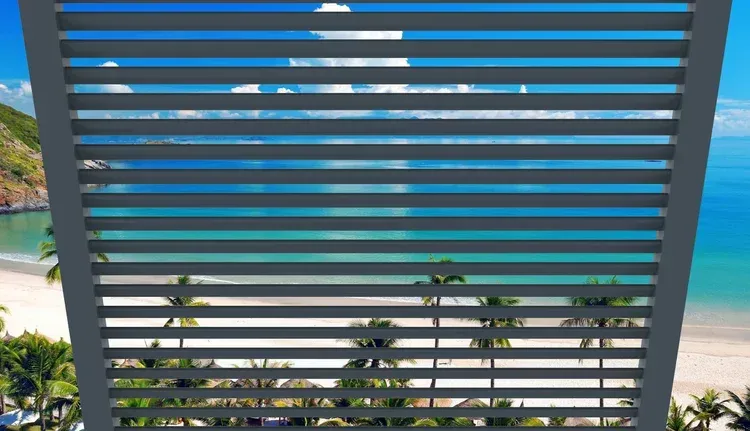 Ocean view through dark slatted railing with palm trees and a turquoise pool below