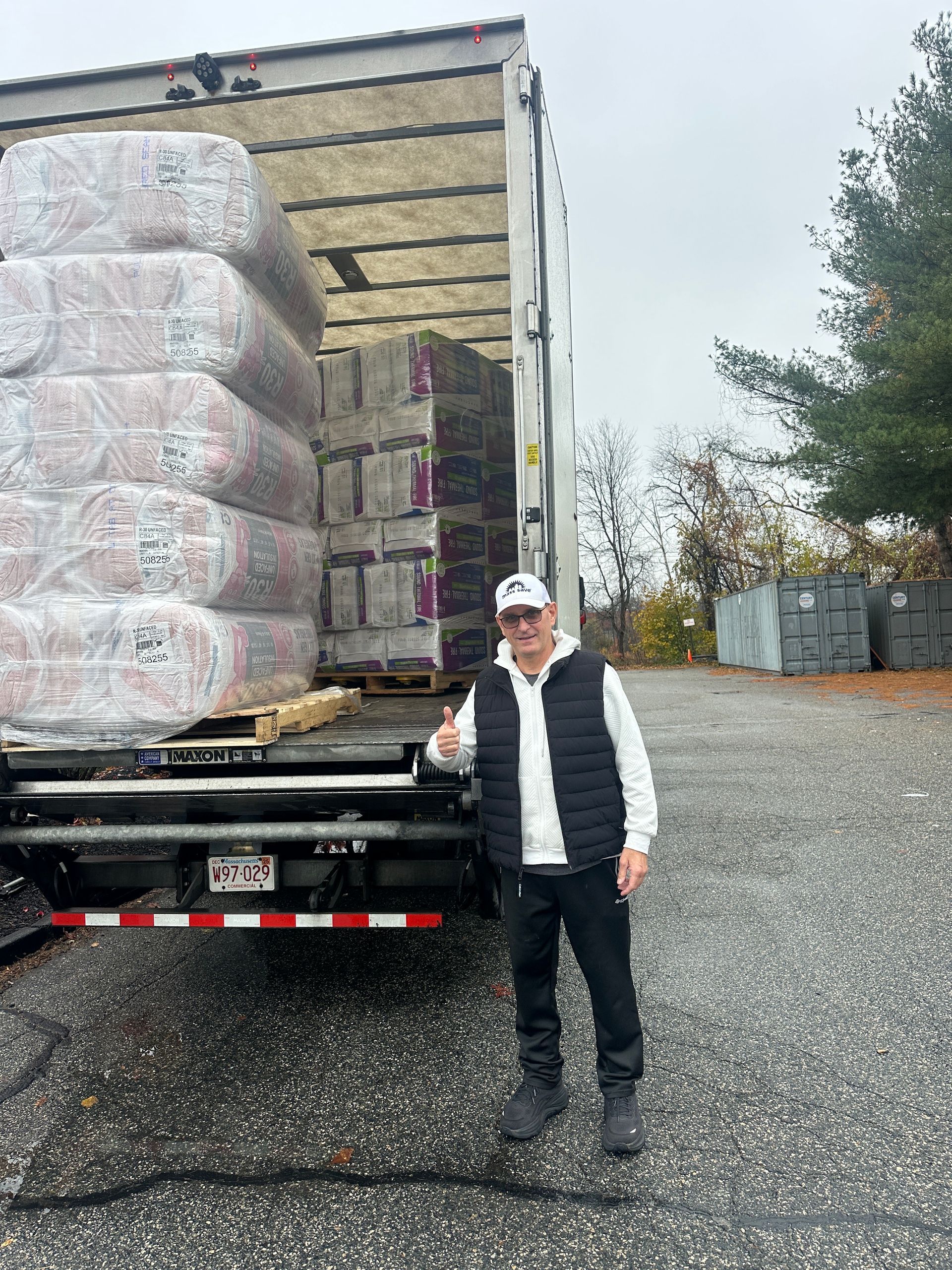 Mass Energy Savers owner Mike Monahan poses next to a box truck full of fresh insulation for Massachusetts homes