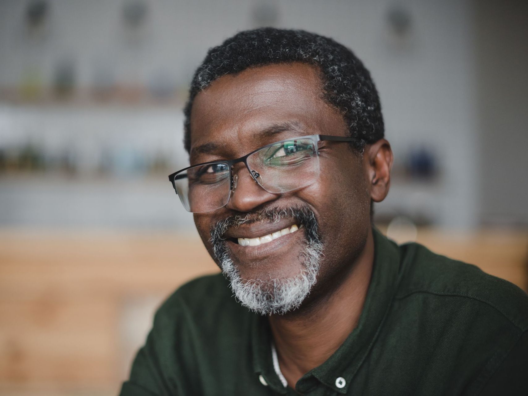 A man with glasses and a beard is smiling for the camera