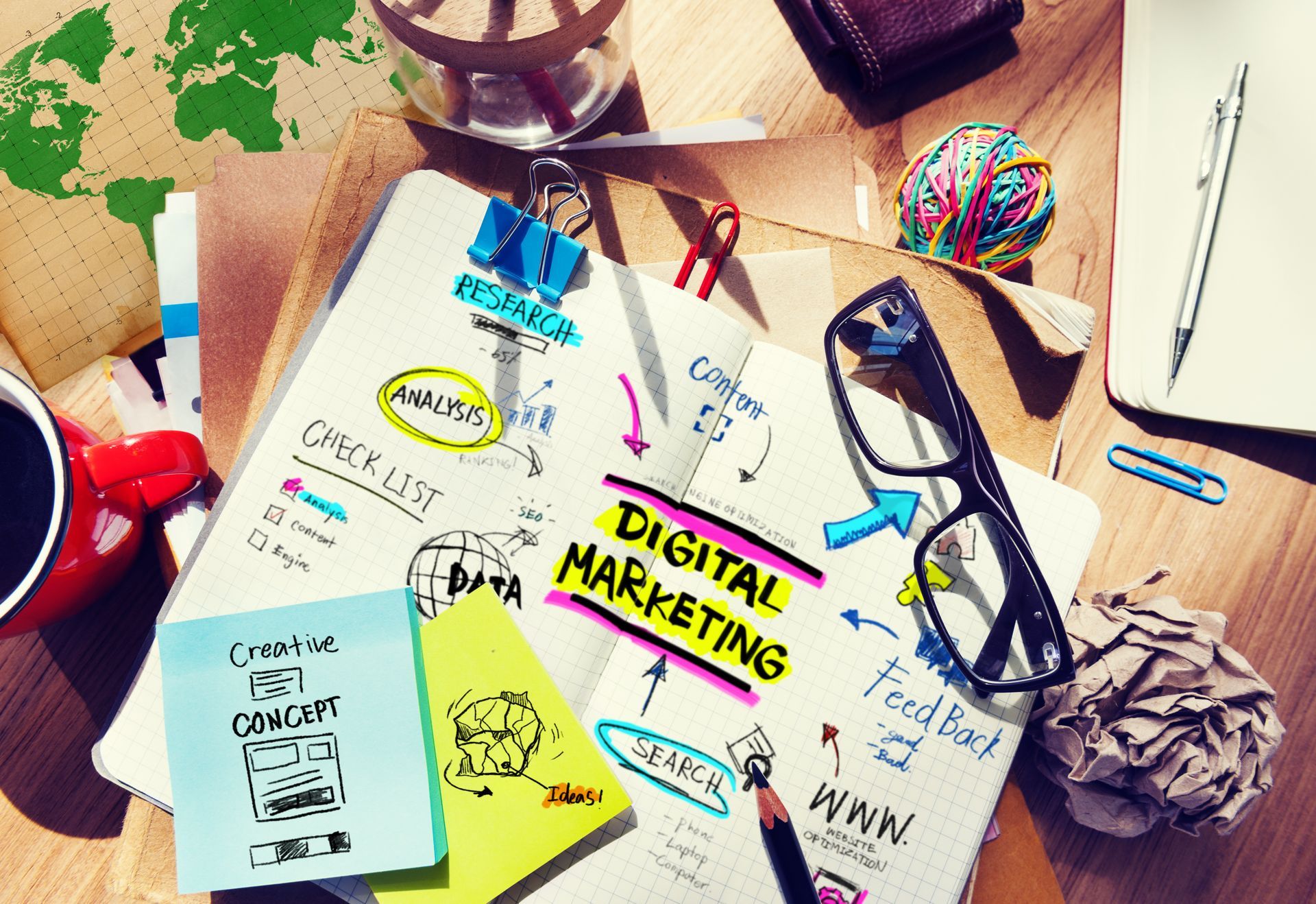 A desk with a notebook that says digital marketing on it. Digital Marketing