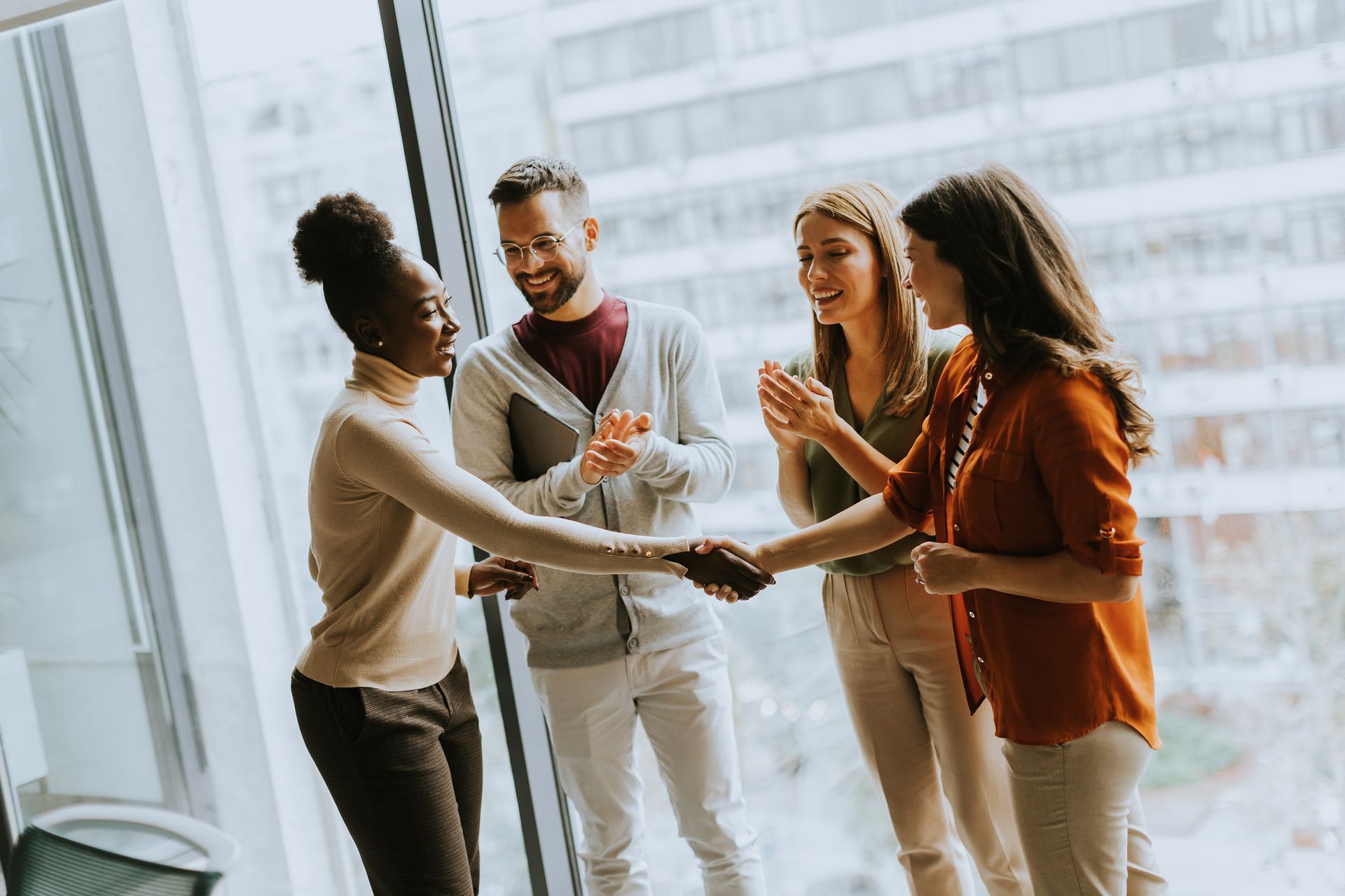 Our #1 Goal is to Help You Grow Your Business! P3 Digital Marketing team working. The image is 4 people standing with 2 shaking hands on a job well done