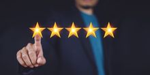 A man is pointing at five stars with his finger.