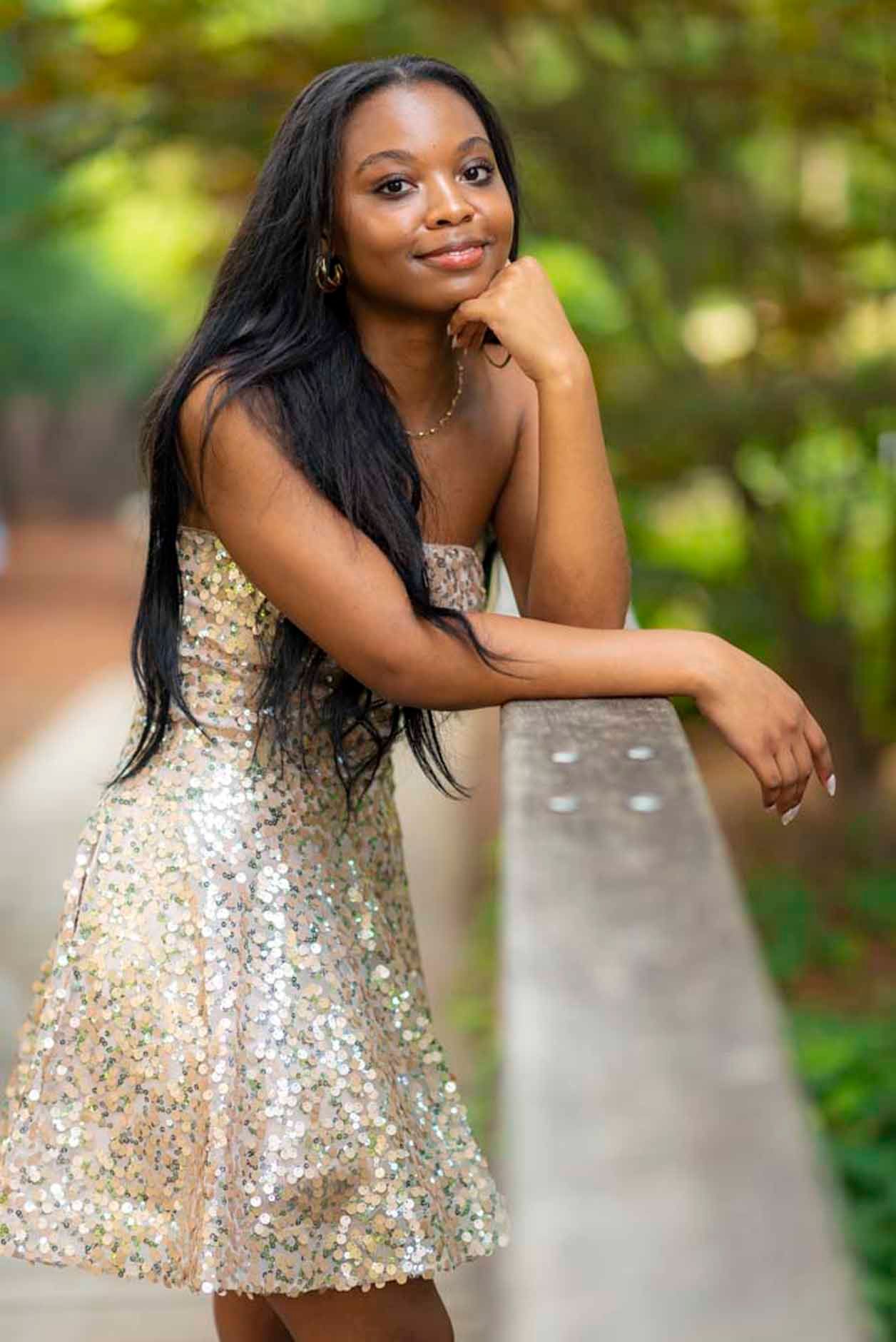 A woman in a sequined dress is leaning on a railing.