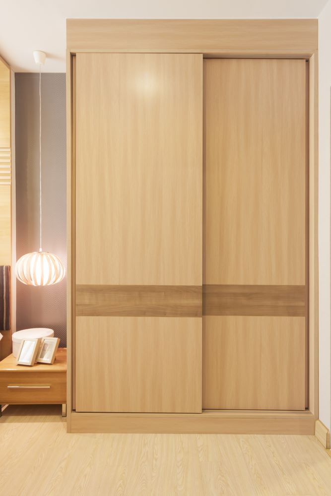 A Bedroom With a Wooden Wardrobe With Sliding Doors — Wardrobe World In Paget, QLD