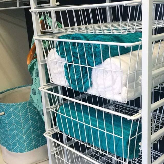 A Stack of Wire Baskets Filled With Towels in a Closet — Wardrobe World In Paget, QLD