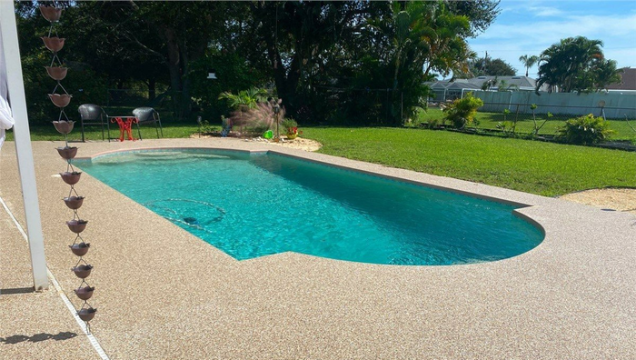 A large swimming pool in the backyard of a house.