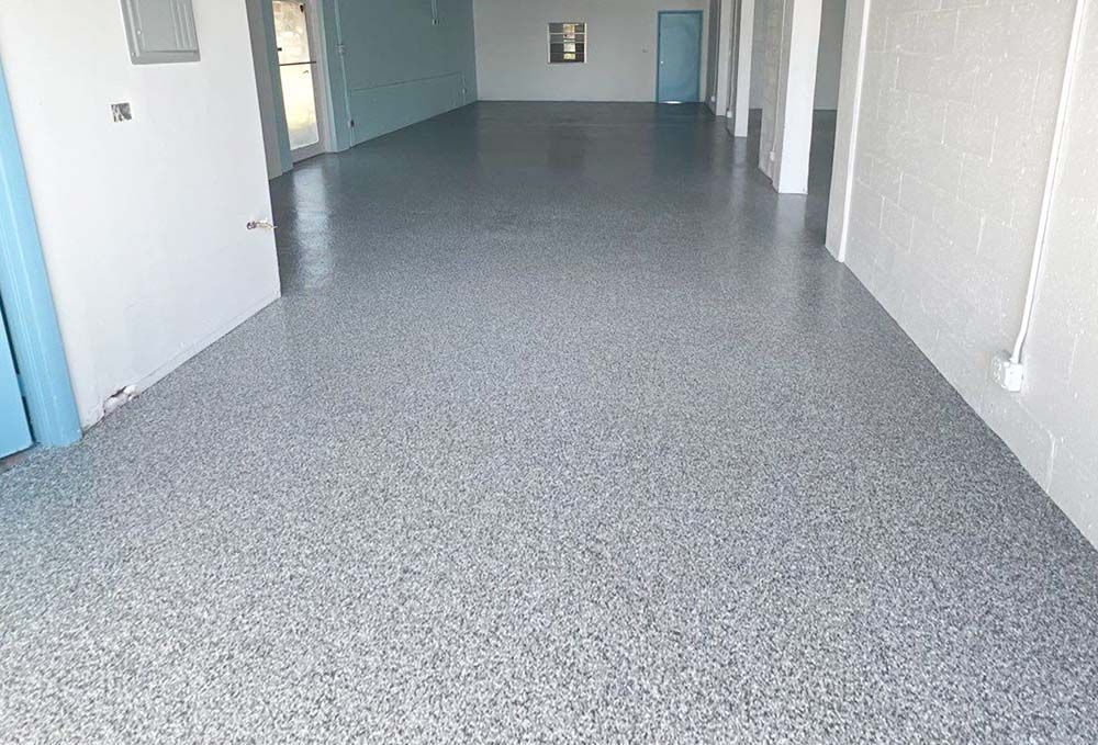 A large empty room with a gray floor and white walls.