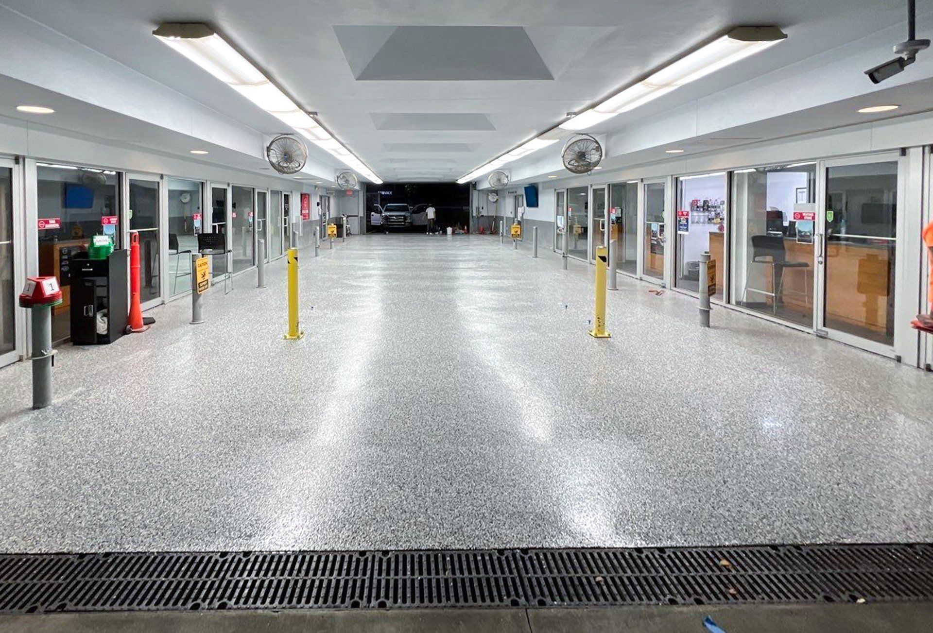 An empty parking garage with a lot of doors and a drain