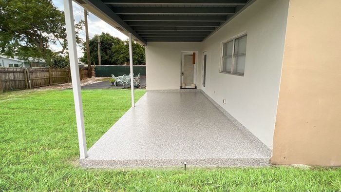 There is a covered patio in the backyard of a house.