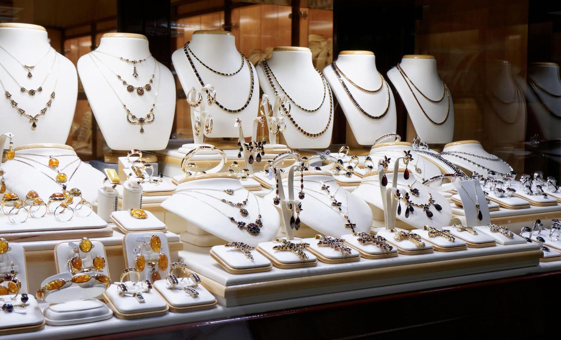 A display of necklaces and rings on mannequins in a store