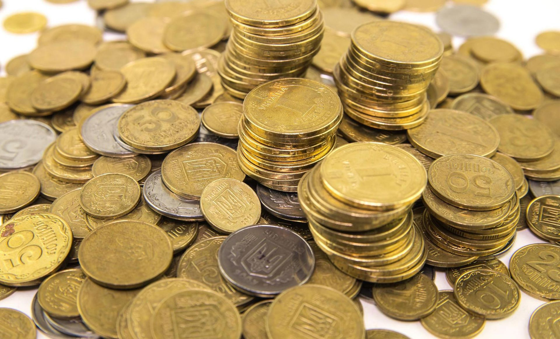 A pile of gold and silver coins on a white surface