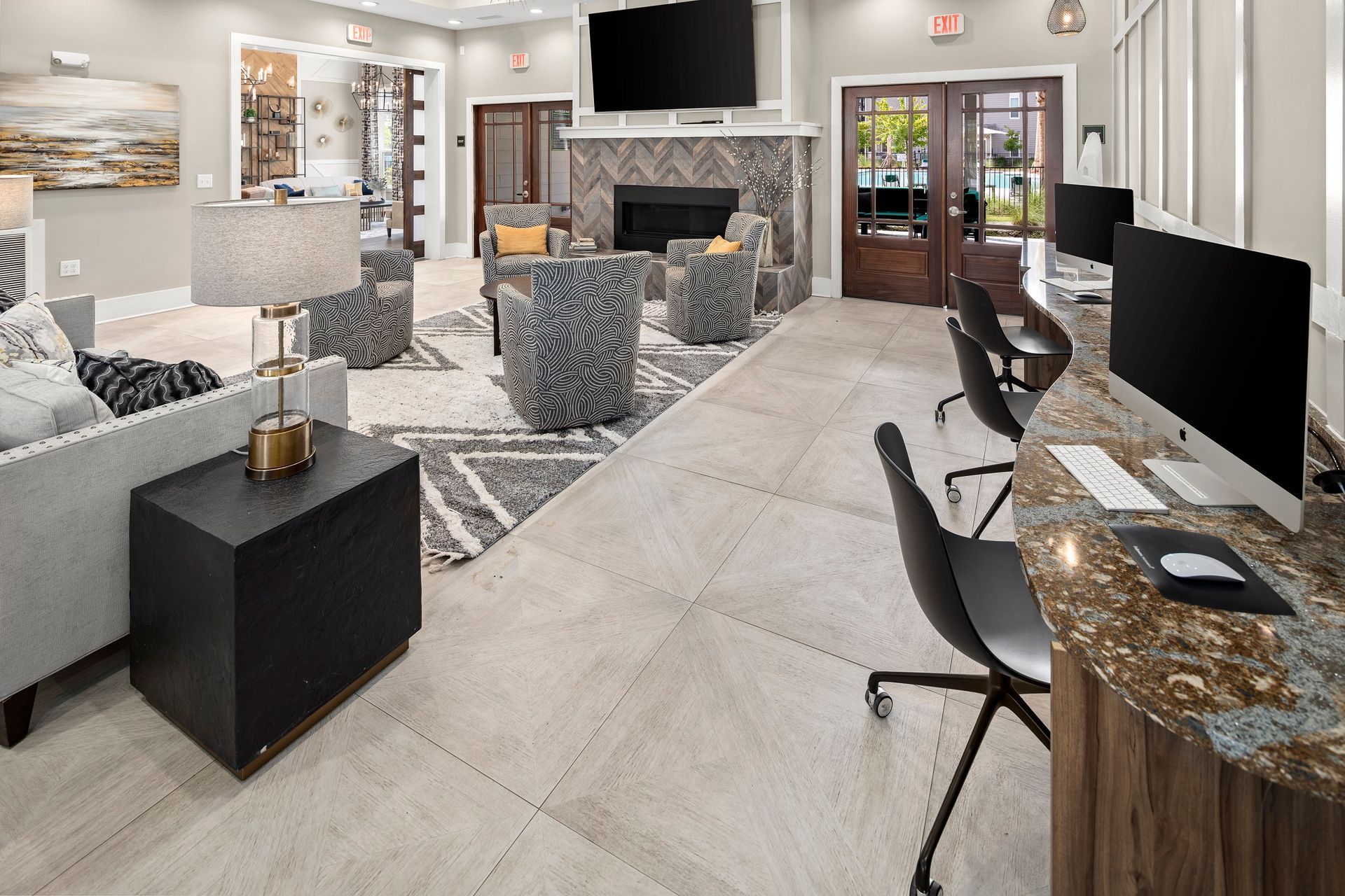 A well-lit room with seating areas, fireplace, and a computer station.