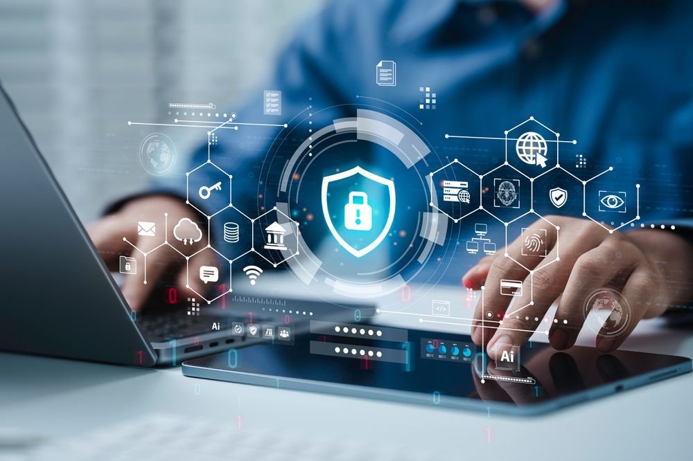 Hands typing on a laptop with a glowing cyber security lock icon overlay and digital network symbols