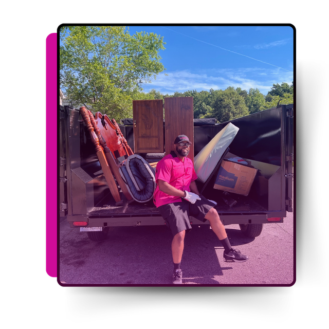 A man sitting on the truck with discarded garbage.