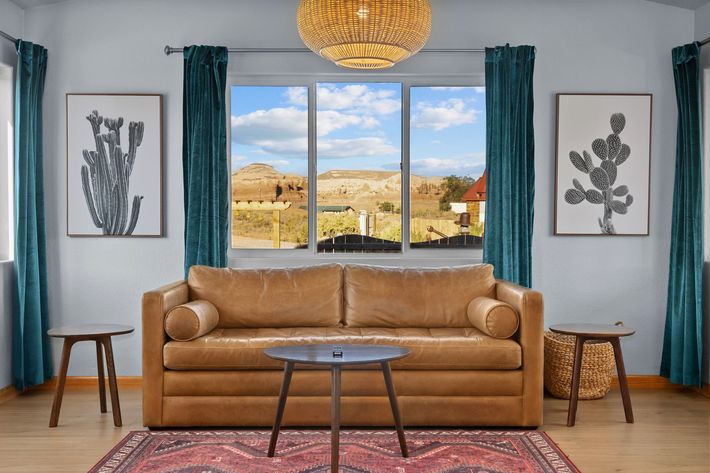 A sign with a bird on it is in the middle of a field.