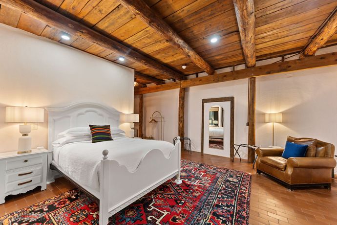 A wicker chair with a blue cushion sits on a deck